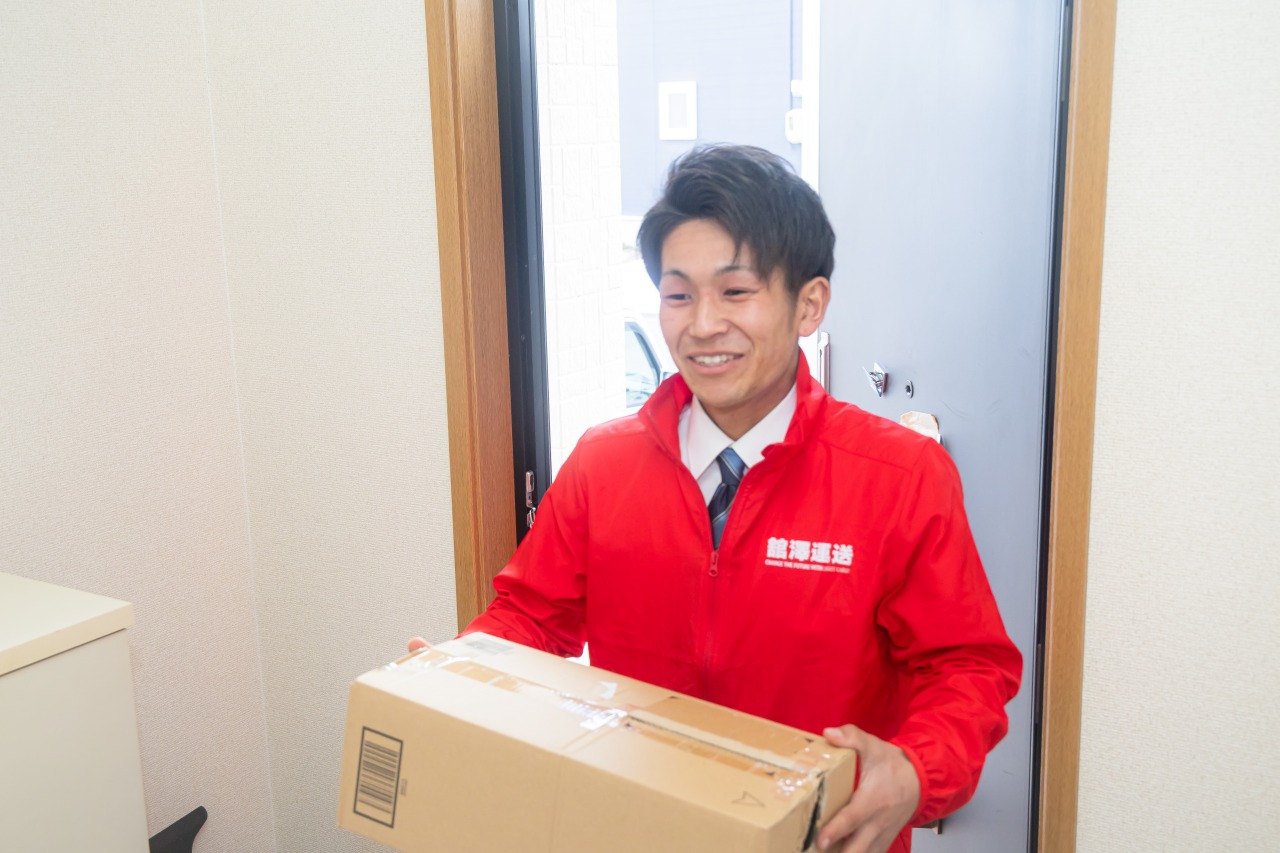 荷物を手渡す配送員